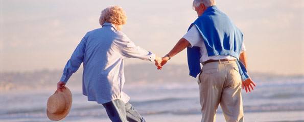 elderly couple walking at beach, ageing