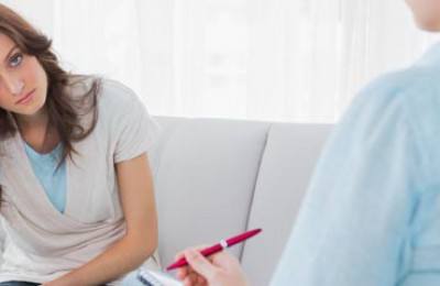 Worried woman sitting with therapist looking at her