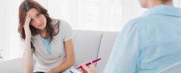 Worried woman sitting with therapist looking at her
