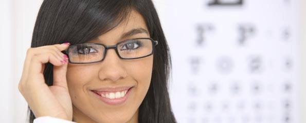 Woman with glasses, eye chart in background