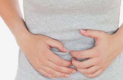 Woman in casuals suffering from stomach ache