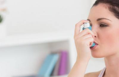 woman taking asthma treatment