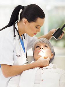 dermatologist inspecting middle aged patient's skin